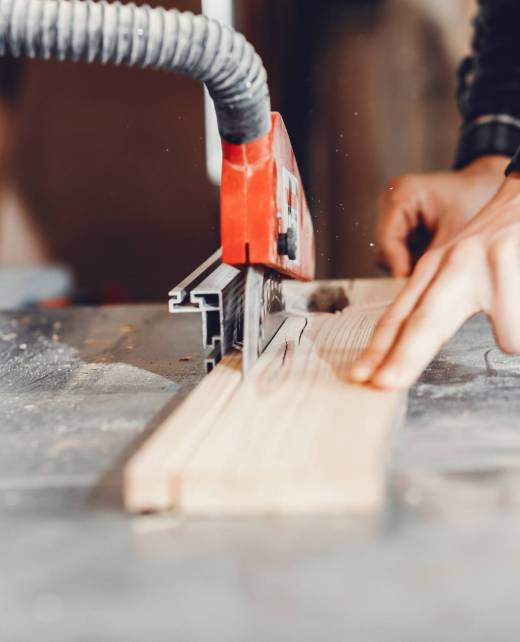 A man carves a tree. The carpenter works in a studio. An engineer provides a tree shape